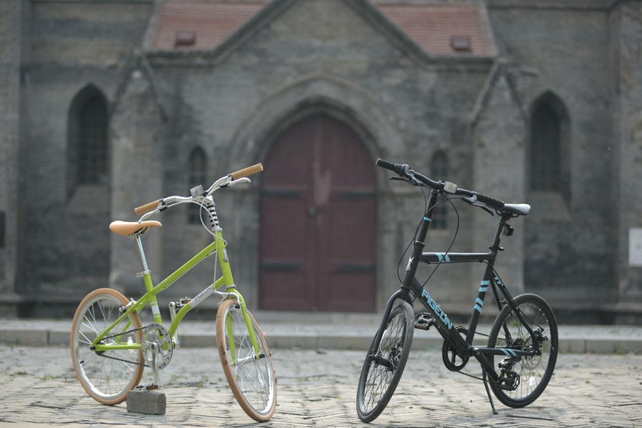 An image of a two bikes parked outside an old stone building.