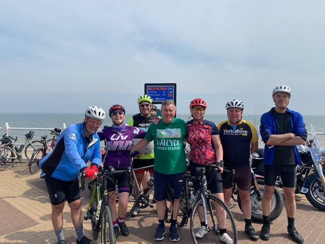 An image of a group of cyclists at the coast.