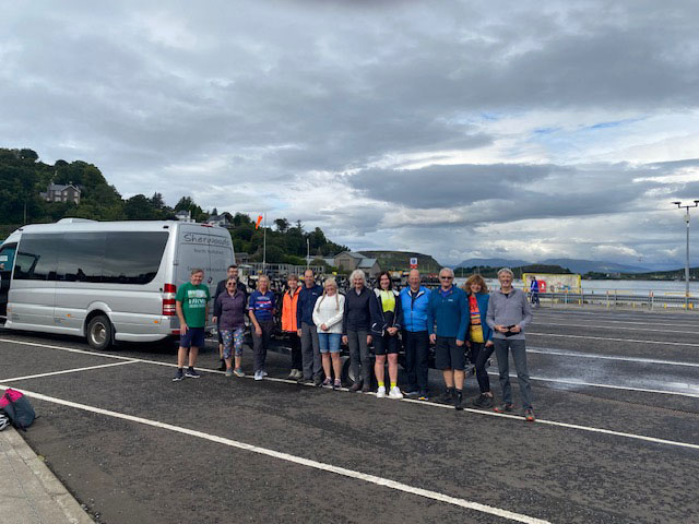 An image of a group of cyclist with a minibus.